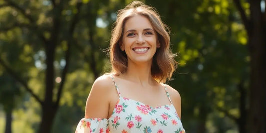 Woman wearing a flowing floral summer dress on a sunny day.