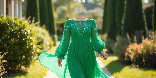 Woman in elegant long-sleeved emerald green midi dress at garden event.